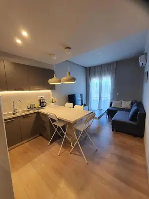 a kitchen and living room with a table and a couch at Keramikos Stylish living in Athens