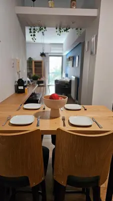 a wooden table with plates and a bowl of fruit on it at Heart of Faliro 2BR 5m Walk to Beach - Newly Renovated in Athens