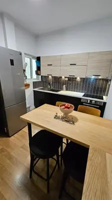 a kitchen with a table with a bowl of fruit on it at Heart of Faliro 2BR 5m Walk to Beach - Newly Renovated in Athens