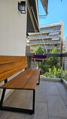 a wooden bench sitting on top of a balcony at Heart of Faliro 2BR 5m Walk to Beach - Newly Renovated in Athens
