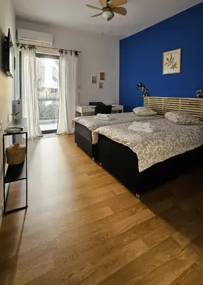 a bedroom with two beds and a blue wall at Heart of Faliro 2BR 5m Walk to Beach - Newly Renovated in Athens