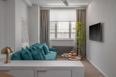 a living room with a blue couch and a window at Leocharous 8 Suites in Athens