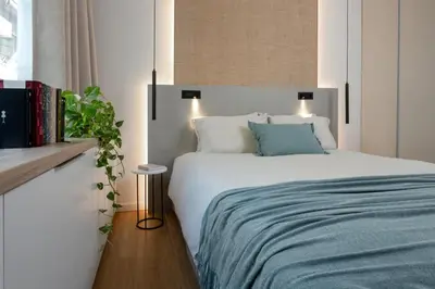 a bedroom with a white bed with a blue blanket at Leocharous 8 Suites in Athens
