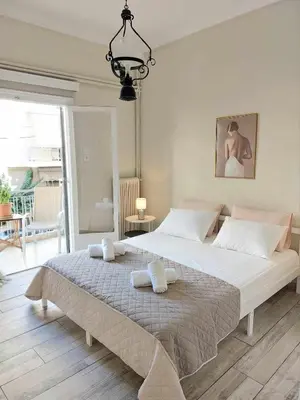 a bedroom with a large bed with two towels on it at Double bed in a room dorm 5' from metro in Athens