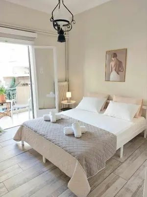 a bedroom with a large bed with two towels on it at Double bed in a room dorm 5' from metro in Athens