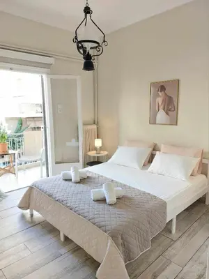 a bedroom with a large bed with two towels on it at Double bed in a room dorm 5' from metro in Athens