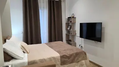 a bedroom with a bed and a flat screen tv at Central Lux Lining B in Athens