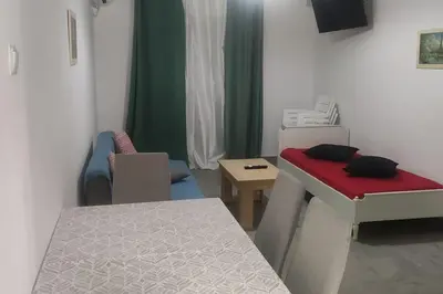 a room with a bed and a table and chairs at Comfortably placed near the sea in Saronida