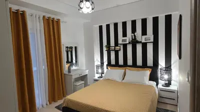 a bedroom with a bed with a black and white striped wall at Central Lux Lining A in Athens