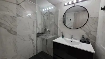 a bathroom with a sink and a shower with a mirror at Central Lux Lining A in Athens