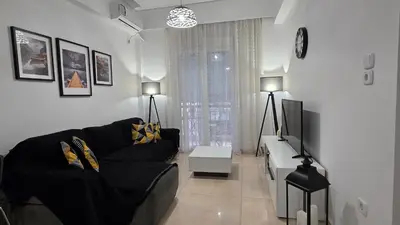 a living room with a black couch and a tv at Central Lux Lining A in Athens