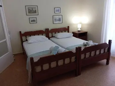 two twin beds in a bedroom with a lamp at ROOM 2 single beds 5' from metro in Athens