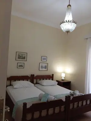 a bedroom with two beds and a chandelier at ROOM 2 single beds 5' from metro in Athens