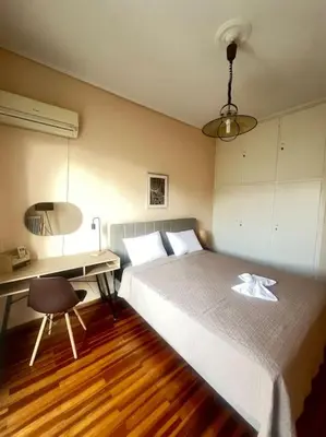 a bedroom with a large bed and a desk at Urban nest in Athens