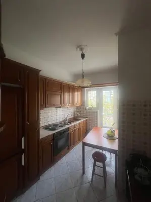 a kitchen with wooden cabinets and a table with a stool at Urban nest in Athens