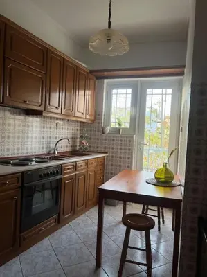 a kitchen with wooden cabinets and a table and a sink at Urban nest in Athens