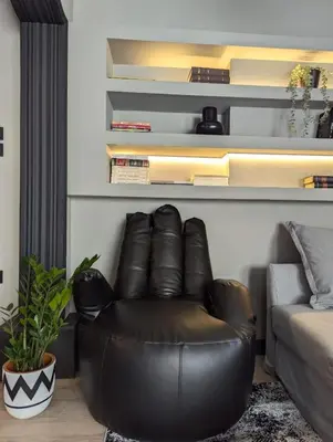 a leather chair in a living room with a couch at Momentum Apartment in Athens