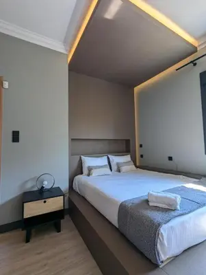 a bedroom with a large bed and a night stand at Momentum Apartment in Athens