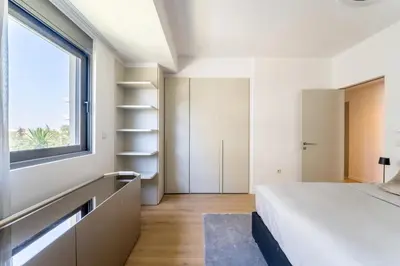 a bedroom with a bed and a window at Glyfada Gem - 3BD apartment in Athens