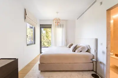 a white bedroom with a bed and a window at Glyfada Gem - 3BD apartment in Athens