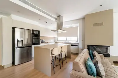 a kitchen and living room with a couch and a table at Glyfada Gem - 3BD apartment in Athens