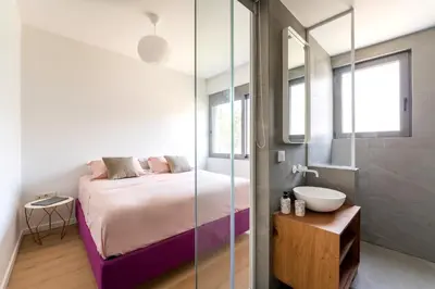 a bedroom with a bed and a glass shower at Glyfada Gem - 3BD apartment in Athens