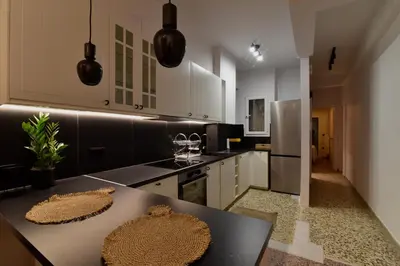 a kitchen with a table and a counter top at Fos Apartment - Ippokratous 2BDR Central Flat in Athens