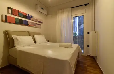 a bedroom with a large white bed and a window at Fos Apartment - Ippokratous 2BDR Central Flat in Athens
