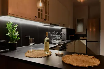 a kitchen with a bottle of wine and two glasses at Fos Apartment - Ippokratous 2BDR Central Flat in Athens