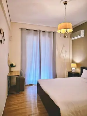 a bedroom with a large bed and a window at Cozy apartment in Voula in Athens