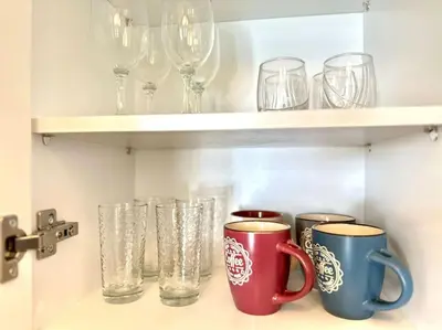 a shelf with cups and glasses on it at Cozy apartment in Voula in Athens