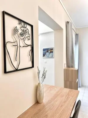 a dining room with a vase on a wooden table at Cozy apartment in Voula in Athens