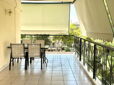 a patio with a table and chairs on a balcony at Cozy apartment in Voula in Athens