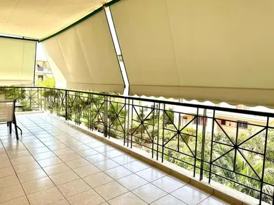 a balcony of a building with a bench on it at Cozy apartment in Voula in Athens