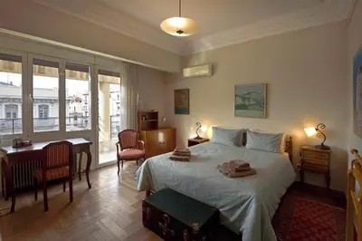 a bedroom with a bed and a desk and a table at Park View Penthouse in Athens