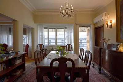 a dining room with a table and chairs and a chandelier at Park View Penthouse in Athens