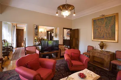 a living room with red chairs and a tv at Park View Penthouse in Athens