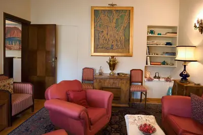 a living room with red chairs and a painting on the wall at Park View Penthouse in Athens