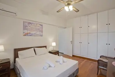 a white bedroom with a bed and a ceiling fan at Afrodite Classic Residence, 2BR, WiFi, City View in Athens