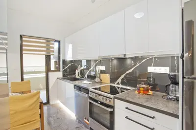 a kitchen with white cabinets and a stove top oven at Afrodite Classic Residence, 2BR, WiFi, City View in Athens