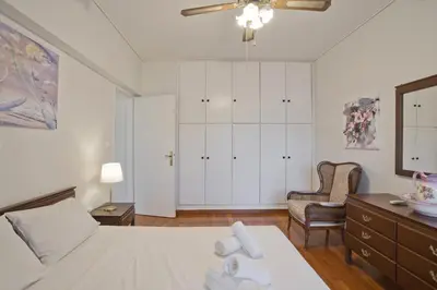 a bedroom with a bed and a dresser and a chair at Afrodite Classic Residence, 2BR, WiFi, City View in Athens