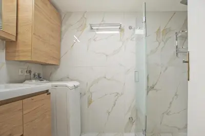 a bathroom with a shower with white marble at Afrodite Classic Residence, 2BR, WiFi, City View in Athens