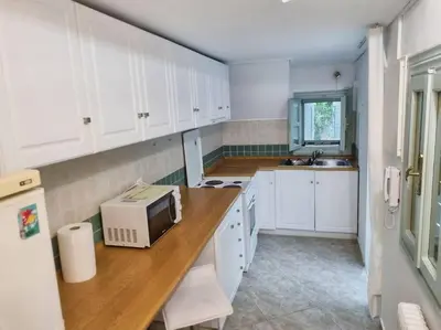 a kitchen with white cabinets and a microwave on a counter at Lemon Tree House with garden in Plaka in Athens