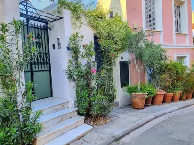 a row of potted plants on the side of a house at Lemon Tree House with garden in Plaka in Athens