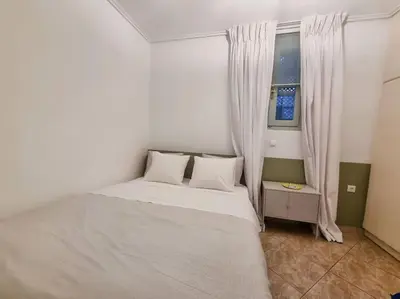 a white bed in a room with a window at Lemon Tree House with garden in Plaka in Athens