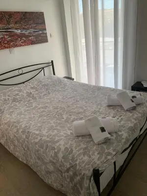a bed with towels on it in a bedroom at Nenas house in Porto Rafti