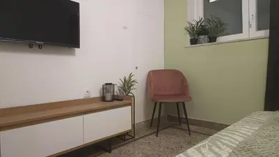 a bedroom with a desk with a chair and a television at Edem apartments in Athens