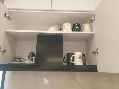 a shelf with cups and mugs in a kitchen at EcoStay Celebrity 2 BDR luxurious apartment by the sea# in Athens