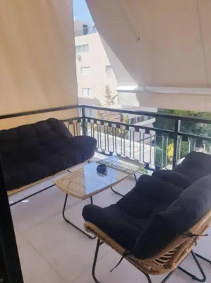 a balcony with a couch and a table and chairs at EcoStay Celebrity 2 BDR luxurious apartment by the sea# in Athens