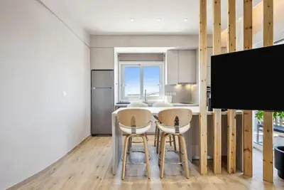a kitchen with a table and two chairs and a tv at Three-Bedroom Elegant City Living in Athens
